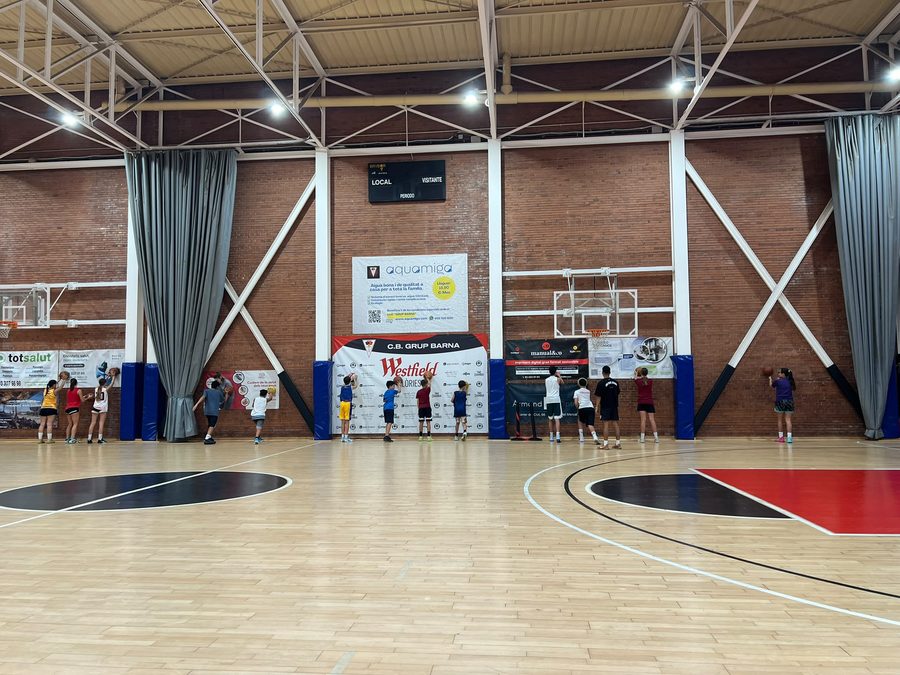 Jugadors i jugadores del campus tirant a cistella a La Nau del Clot
